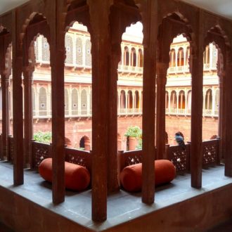 Curved arches and intricate jaalis along the corridors at Narendra Bhawan